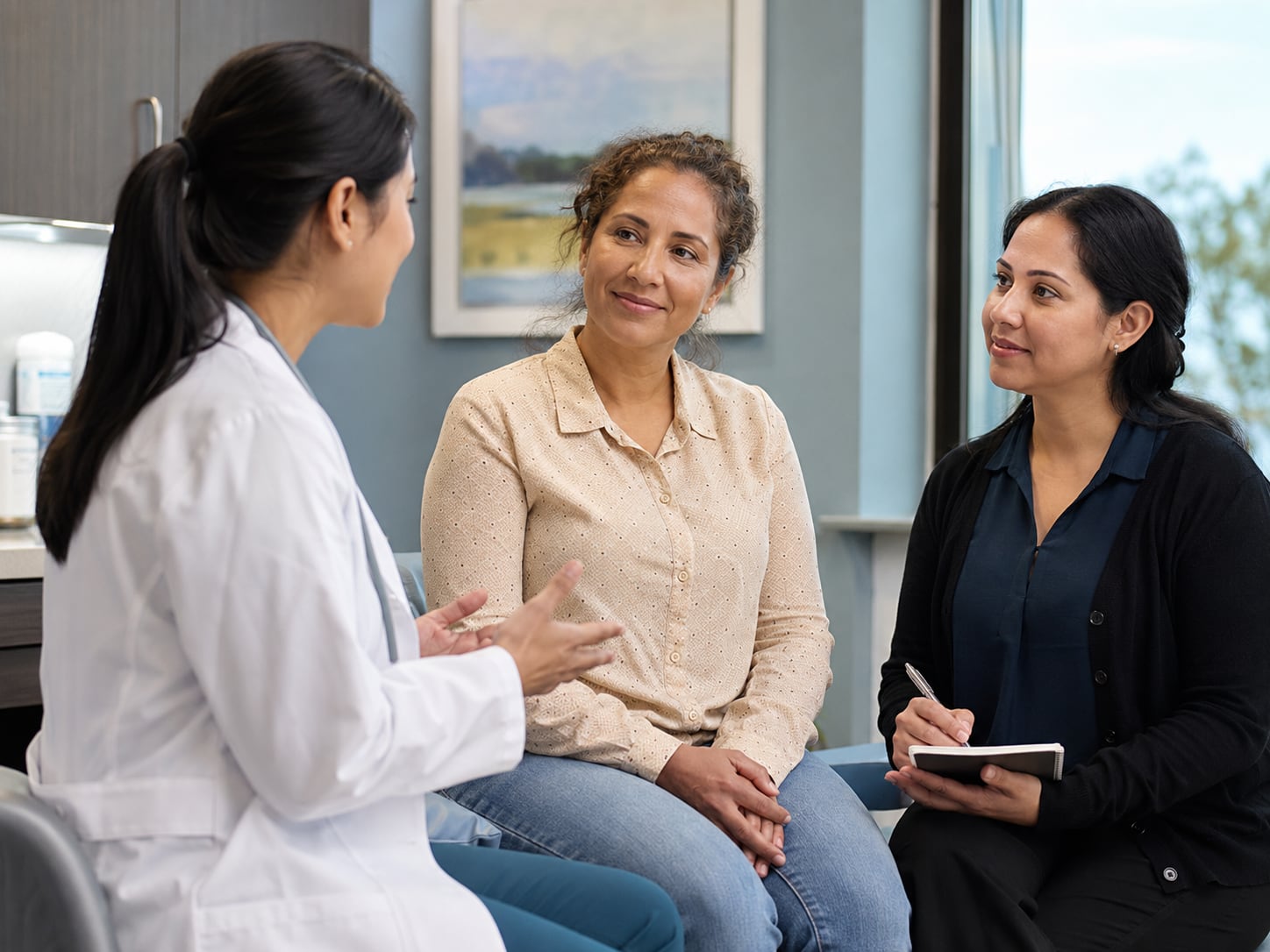 A female doctor talks with two women in a clinic hallway