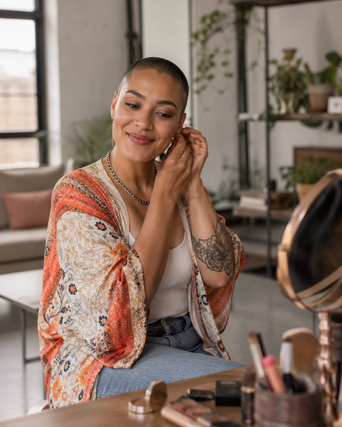 A woman puts in an earring while smiling at home
